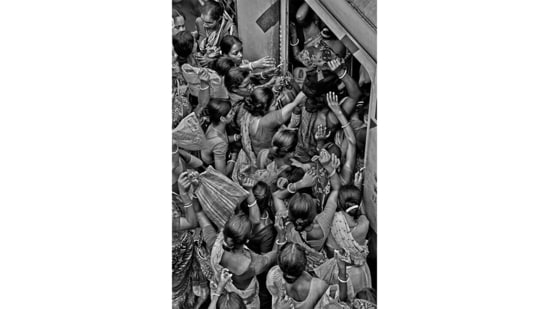 Tens of thousands of women come to Kolkata every day from southern suburbs to work as domestic help or labourers. This image depicts their struggle to get on the train back home.(Photo by Sandipan Mukherjee)