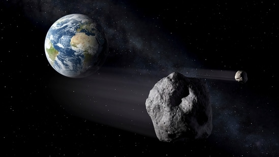 In this artistic rendering, two asteroids fly past Earth. (AP)