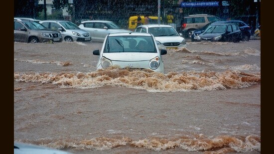 Vehicles stranded on a waterlogged road amid heavy rain in Panchkula on Friday. (Sant Arora/HT)