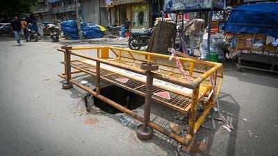 The sinkhole on Arya Samaj Road covered by a police barricade in Karol Bagh in New Delhi on Saturday. (Sanchit Khanna/HT Photo) The sinkhole on Arya Samaj Road covered by a police barricade in Karol Bagh in New Delhi on Saturday. (Sanchit Khanna/HT Photo)
