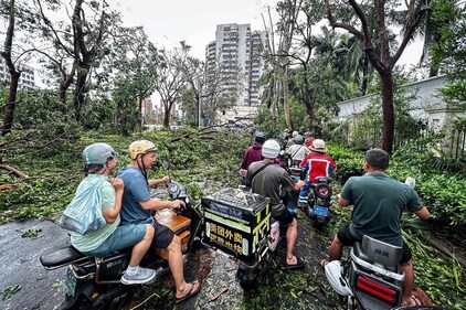 People ride scooters past falling trees after Super Typhoon Yagi hit Haikou, in southern China's Hainan province on September 7, 2024. (AFP) People ride scooters past falling trees after Super Typhoon Yagi hit Haikou, in southern China's Hainan province on September 7, 2024. (AFP)
