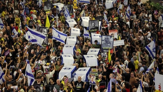 TOPSHOT - Demonstrators carry symbolic coffins during an anti-government protest calling for action to secure the release of Israeli hostages held captive since the October 7 attacks by Palestinian militants in the Gaza Strip, in front of the Israeli Defence Ministry in Tel Aviv on September 5, 2024, amid the ongoing war between Israel and the militant Hamas group. (Photo by Jack GUEZ / AFP) (AFP)