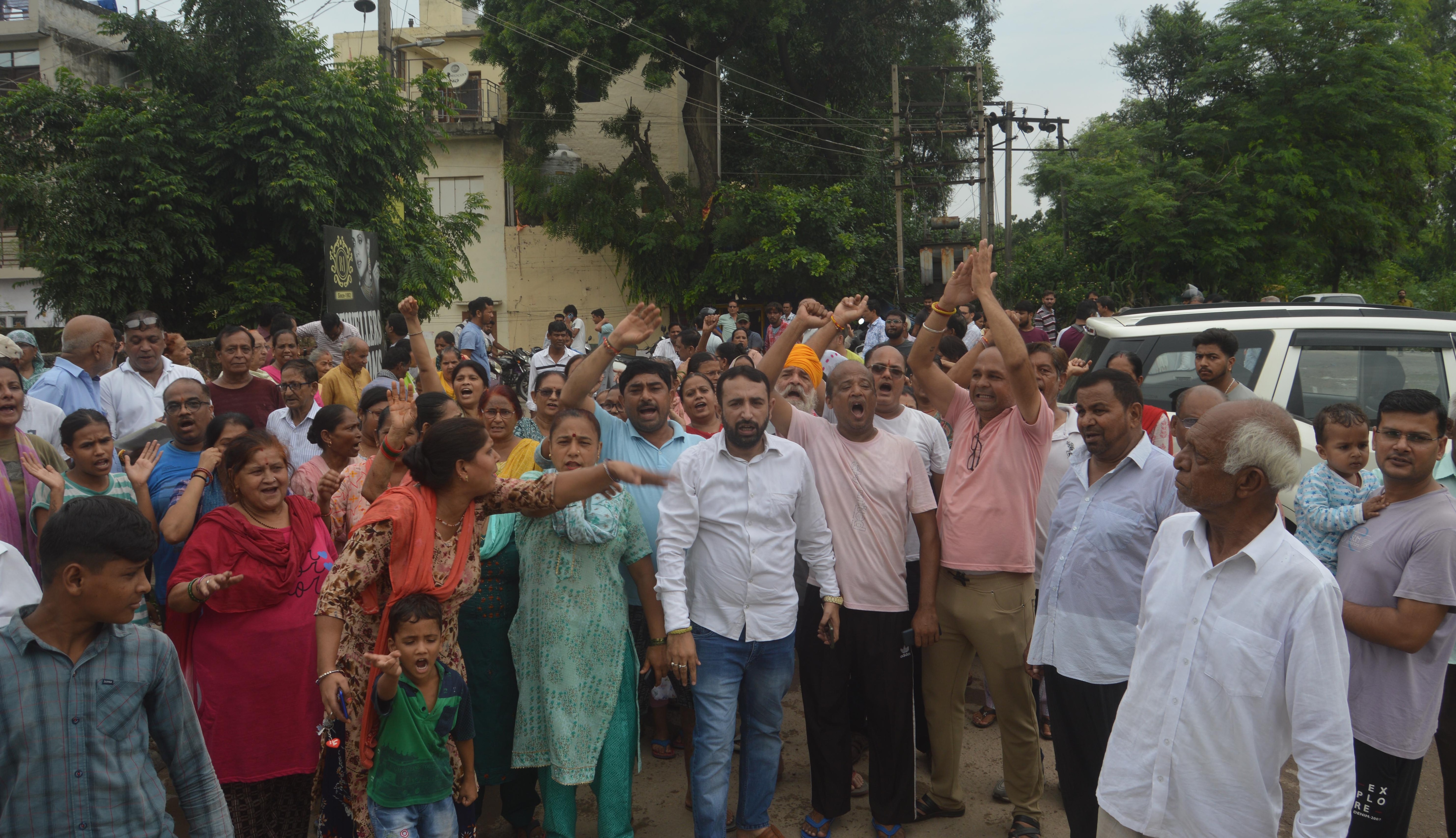 Residents of Sector 19 raising slogans against the administration. (Sant Arora/HT)