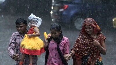 A family run as they cross a street during heavy rain in Hyderabad, India, Friday, Sept. 6, 2024. (AP) A family run as they cross a street during heavy rain in Hyderabad, India, Friday, Sept. 6, 2024. (AP)