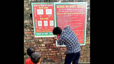 Posters being pasted to educate the villagers. (HT)