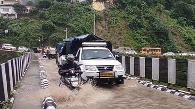 Vehicles crossing water logged bridge after heavy rain in Mandi. (Birbal Sharma/HT) Vehicles crossing water logged bridge after heavy rain in Mandi. (Birbal Sharma/HT)