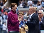 Former tennis player Andre Agassi presents the trophy to Italy's Jannik Sinner.
