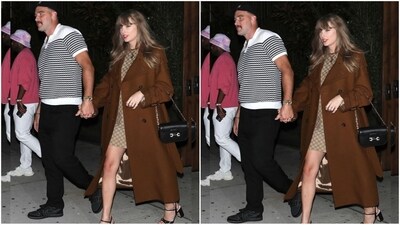 Taylor Swift was snapped in NYC with Travis Kelce, wearing a chic Gucci mini dress and a brown trench coat. She accessorised with a black purse, necklace, earrings and rings, completing her stylish look. (Instagram/@JustJared)