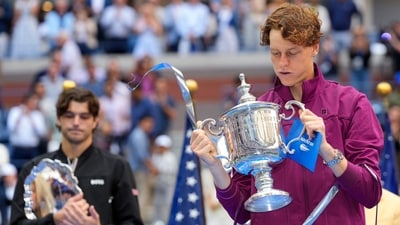 Jannik Sinner, of Italy, holds the championship trophy as Taylor Fritz, of the United States, looks on. (AP) Jannik Sinner, of Italy, holds the championship trophy as Taylor Fritz, of the United States, looks on. (AP)