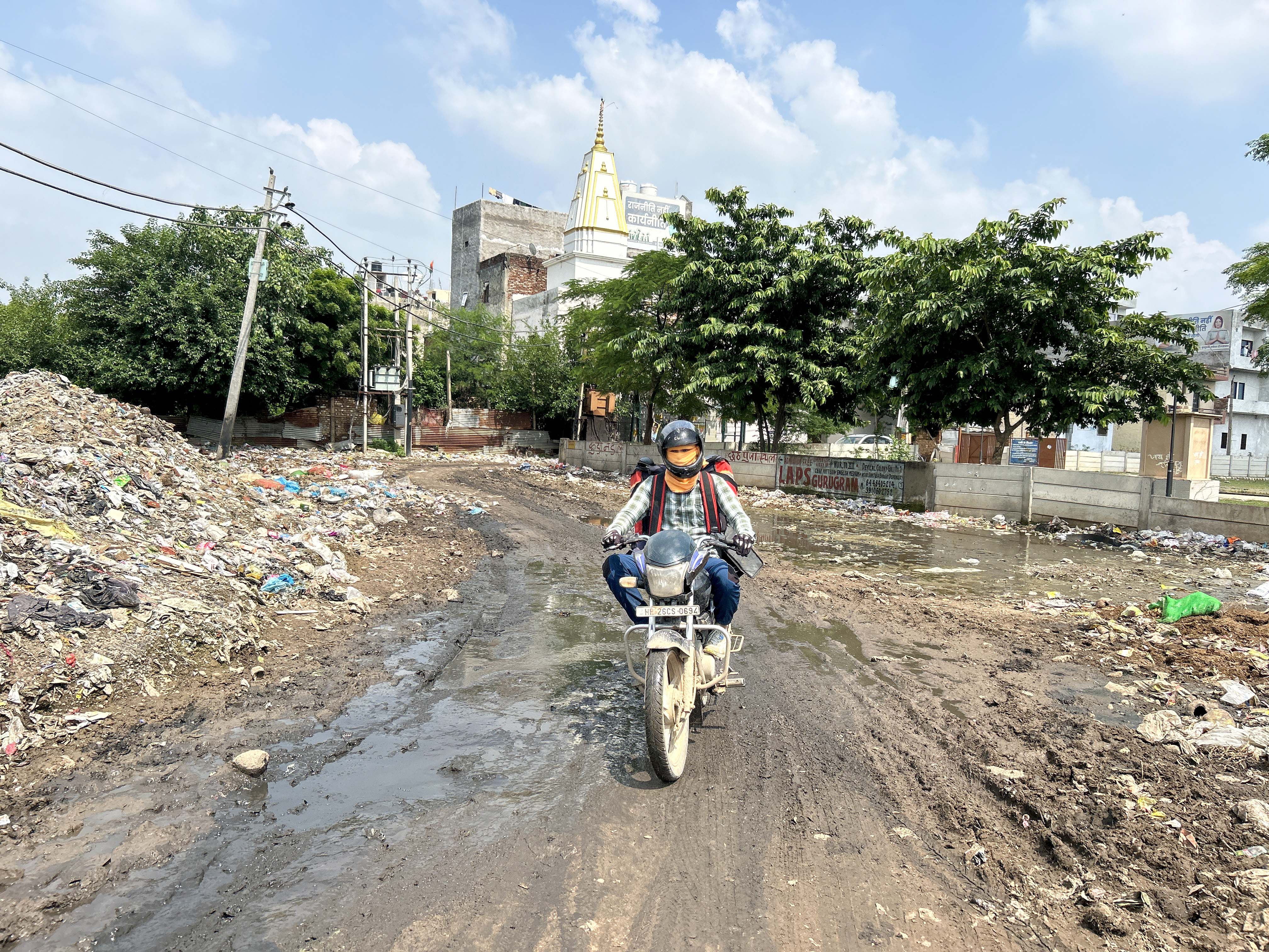 A damaged road on the main entry point of Devi Lal colony surrounded by illegally dumped garbage. (Parveen Kumar/HT Photo) A damaged road on the main entry point of Devi Lal colony surrounded by illegally dumped garbage. (Parveen Kumar/HT Photo)