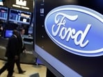 The logo for the Ford Motor Company appears above a post on the floor of the New York Stock Exchange. The logo for the Ford Motor Company appears above a post on the floor of the New York Stock Exchange.