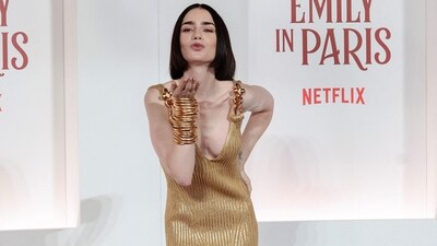 Lily Collins attended the European premiere of Netflix's *Emily in Paris* Season 4 at the Moderno cinema in Rome, dazzling in a Schiaparelli gold knit dress. She styled her look with stacked gold bangles and black high heels. (REUTERS/Remo Casilli)