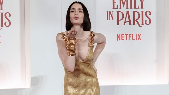 Lily Collins attended the European premiere of Netflix's *Emily in Paris* Season 4 at the Moderno cinema in Rome, dazzling in a Schiaparelli gold knit dress. She styled her look with stacked gold bangles and black high heels.(REUTERS/Remo Casilli)