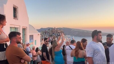 Tourists watching and photographing the sunset in Oia on the island of Santorini (Sofia Kleftaki/DW ) Tourists watching and photographing the sunset in Oia on the island of Santorini (Sofia Kleftaki/DW )