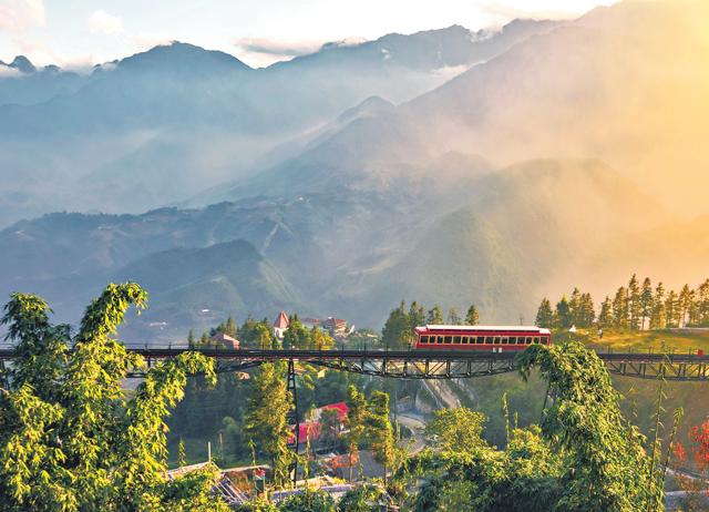 When in Sa Pa, take a train and then the cable car to the top of Fansipan, the country’s highest peak. (ADOBE STOCK)