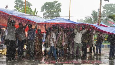 Protestors take cover during rains as junior doctors continued their 'cease work' and sit-in demonstration against the RG Kar Hospital incident for the third consecutive day, outside Swasthya Bhavan in Kolkata on Friday. (PTI) Protestors take cover during rains as junior doctors continued their 'cease work' and sit-in demonstration against the RG Kar Hospital incident for the third consecutive day, outside Swasthya Bhavan in Kolkata on Friday. (PTI)