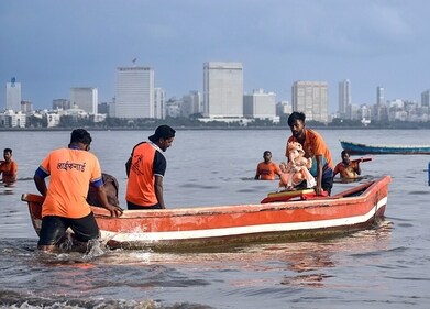 Devotees take the idol of Lord Ganesha in a boat for the visarjan ceremony. (Vijay Gohil/ANI) Devotees take the idol of Lord Ganesha in a boat for the visarjan ceremony. (Vijay Gohil/ANI)
