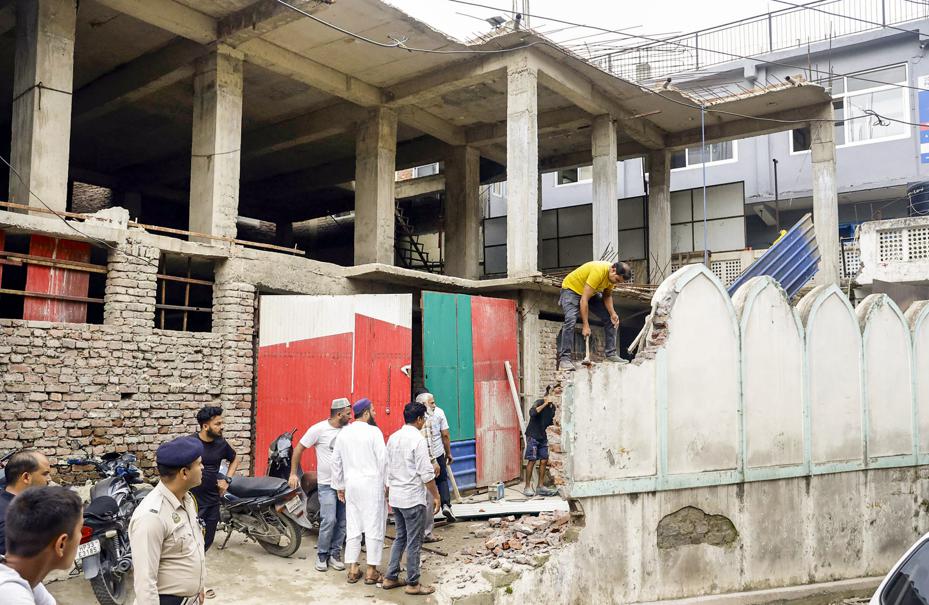 An alleged illegal portion of a mosque being demolished by the mosque management on the order of municipal commissioner in Mandi Friday. (PTI Photo) An alleged illegal portion of a mosque being demolished by the mosque management on the order of municipal commissioner in Mandi Friday. (PTI Photo)