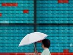 A woman walks in front of an electronic quotation board displaying stock prices of Nikkei 225 on the Tokyo Stock Exchange in Tokyo on September 4, 2024. Japan's key Nikkei index dropped more than three percent on September 4, weighed down by falls on Wall Street following lacklustre manufacturing data. (Photo by Kazuhiro NOGI / AFP)