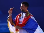 Novak Djokovic poses with his Olympic gold medal.