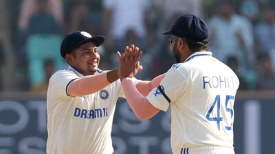 Indian captain Rohit Sharma celebrates a wicket with Sarfaraz Khan. (REUTERS)