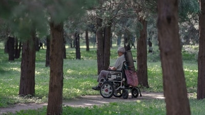 A person on a wheel chair at a park in Beijing, China, on Saturday, Sept. 14, 2024. China will raise the retirement age for the first time since 1978, a move likely to slow a decline in the labor force and support the economy. Photographer: Na Bian/Bloomberg (Bloomberg) A person on a wheel chair at a park in Beijing, China, on Saturday, Sept. 14, 2024. China will raise the retirement age for the first time since 1978, a move likely to slow a decline in the labor force and support the economy. Photographer: Na Bian/Bloomberg (Bloomberg)