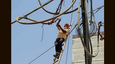 PSPCL line man repair the wire near fountain chowk area in Ludhiana. (HT Photo)