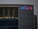 The logo of the Adani Group is seen on the facade of one of its buildings on the outskirts of Ahmedabad. Adani Enterprises and Wilmar International are set to divest a 13% stake in Adani Wilmar, valued at $735 million, to adhere to regulations requiring non-founders to hold at least 25% within three years of listing.