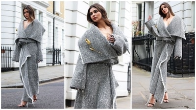 Mouni Roy takes over London in style, stunning in a black and white draped ensemble adorned with a golden rose embellishment, showcasing her fashion prowess. (Instagram) Mouni Roy takes over London in style, stunning in a black and white draped ensemble adorned with a golden rose embellishment, showcasing her fashion prowess. (Instagram)