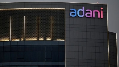 The logo of the Adani Group is seen on the facade of one of its buildings on the outskirts of Ahmedabad. Adani Enterprises and Wilmar International are set to divest a 13% stake in Adani Wilmar, valued at $735 million, to adhere to regulations requiring non-founders to hold at least 25% within three years of listing. (Reuters)
