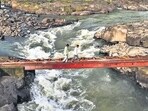 Villagers and schoolgoing children would use a dilapidated bridge to cross the Vaitarna river and reach Dapora village, five km away. Three years ago, the wooden plank they were using was replaced by a temporary iron bridge, now in bad condition. (Raju Shinde/HT Photo)