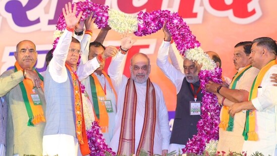 Union home minister Amit Shah acknowledges supporters at an election rally in Haryana's Loharu.