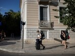 Tourists carry their luggage in the neighborhood of Koukaki, in Athens, Greece. Travelling to Athens? Here's how new rental rules in Greece could affect your vacation 
