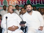Leader of Opposition Tejashwi Yadav holds a mic while RJD Chief Lalu Prasad addresses party workers during 28th foundation of Rashtriya Janata Dal, at the party office in Patna.