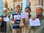 Voters show their voting slips as they wait to cast votes at a polling station during the first phase of Jammu and Kashmir Assembly elections (PTI Photo) Voters show their voting slips as they wait to cast votes at a polling station during the first phase of Jammu and Kashmir Assembly elections (PTI Photo)