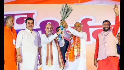 Home Minister Amit Shah with Haryana Chief Minister Nayab Singh Saini and BJP candidate JP Dalal during a rally for Haryana Assembly elections, in Loharu, on Tuesday. (PTI)