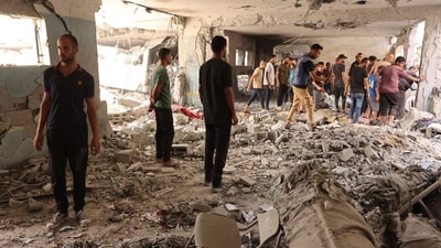 People check debris after a school used as shelter by displaced Palestinians was hit by an Israeli strike in the Shujaiya neighbourhood of Gaza City on September 18, 2024, amid the ongoing war between Israel and the militant group Hamas. (Photo by Omar AL-QATTAA / AFP) (AFP)