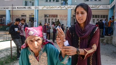 An elderly voter, assisted by her granddaughter, shows her ink-marked finger after voting in Anantnag during the first phase of the assembly elections. (PTI) An elderly voter, assisted by her granddaughter, shows her ink-marked finger after voting in Anantnag during the first phase of the assembly elections. (PTI)