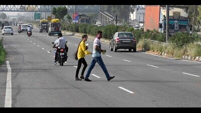 Pedestrians crossing Jalandhar by-pass in Ludhiana on Tuesday. (Gurpreet Singh/Hindustan Times)
