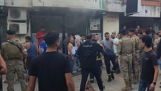 Lebanese soldiers and firefighters gather outside a mobile shop after what is believed to be the result of a walkie-talkie exploding inside it, in the southern port city of Sidon, Lebanon, Wednesday, Sept. 18, 2024. (AP)