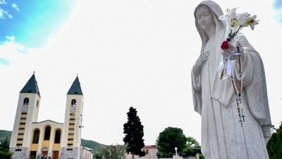 This photograph shows a statue depicting Virgin Mary, on the square, in front of St. Jacob church in Southern-Bosnian town of Medjugorje. The Vatican announced its recognition of the shrine of Medjugorje in Bosnia-Herzegovina, without commenting on the Virgin's presumed messages to the faithful, who have been gathering there by the millions for over 40 years, during a press conference today on September 19, 2024 on Medjugorje apparitions. Vatican approves pilgrimages to Medjugorje: Virgin Mary’s apparitions spark religious tourism (Photo by ELVIS BARUKCIC / AFP) This photograph shows a statue depicting Virgin Mary, on the square, in front of St. Jacob church in Southern-Bosnian town of Medjugorje. The Vatican announced its recognition of the shrine of Medjugorje in Bosnia-Herzegovina, without commenting on the Virgin's presumed messages to the faithful, who have been gathering there by the millions for over 40 years, during a press conference today on September 19, 2024 on Medjugorje apparitions. Vatican approves pilgrimages to Medjugorje: Virgin Mary’s apparitions spark religious tourism (Photo by ELVIS BARUKCIC / AFP)