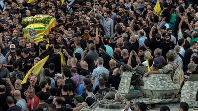 Lebanese army soldiers sit on their armoured vehicle as mourners carry the coffin of Mohammed Mahdi, son of Hezbollah legislator Ali Ammar, who was killed Tuesday after his handheld pager exploded. (AP) Lebanese army soldiers sit on their armoured vehicle as mourners carry the coffin of Mohammed Mahdi, son of Hezbollah legislator Ali Ammar, who was killed Tuesday after his handheld pager exploded. (AP)