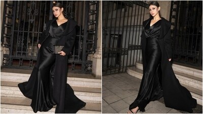 Mouni styled the cowl-neck ensemble with a floor-length black wool trench coat featuring exaggerated shawl lapels and a cascading train on the back. Black strappy heels, a centre-parted sleek bun, a large black clutch, pink-tinted lips, matching eye shadow, rouge on the cheeks, beaming highlighter, winged eyeliner, feathered brows, and mascara-adorned lashes rounded off the glam.&nbsp; 