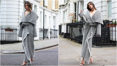 Mouni wore a draped cocoon jacket with a hand-embroidered carnation brooch to the fashion show. It features a plunging neckline, full-length sleeves, and an oversized silhouette. She styled the coat with a matching draped asymmetric textured tweed skirt, black stilettos, striking glam, and centre-parted loose locks.&nbsp; 