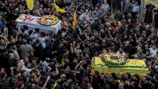 Mourners carry the coffins of victims who were killed Tuesday after their handheld pagers exploded, during their funeral procession in the southern suburb of Beirut, Lebanon, Wednesday, Sept. 18, 2024. (AP Photo/Bilal Hussein) (AP)