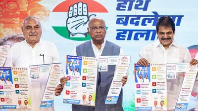 Congress president Mallikarjun Kharge (centre) along with former Haryana chief minister Bhupinder Singh Hooda and party general secretary KC Venugopal releasing the manifesto of 7 guarantees for the October 5 assembly elections, in New Delhi on Wednesday. (ANI Photo)