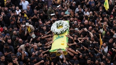 Mourners gather at the funeral of Hezbollah members Fadel Abbas Bazzi and Ahmad Ali Hassan after hand-held radios and pagers used by armed group Hezbollah detonated across Lebanon on September 19. (Reuters)