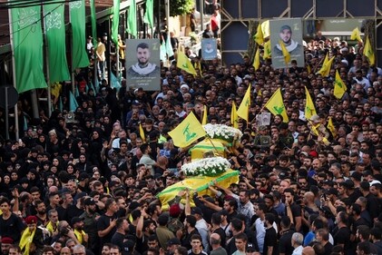 Mourners carry the coffins of Hezbollah members Fadel Abbas Bazzi and Ahmad Ali Hassan, after hand-held radios and pagers used by armed group Hezbollah detonated across Lebanon, during their funeral in Ghobeiry, Beirut southern suburbs, Lebanon September 19, 2024. (Reuters)