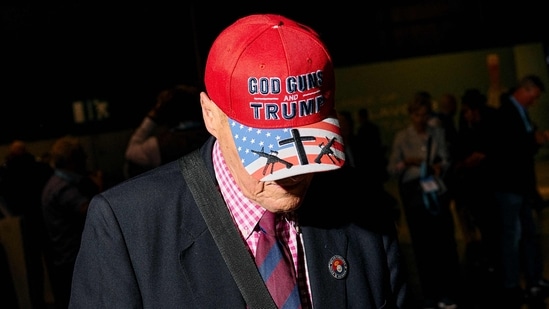A delegate wearing a US-themed cap reading "God, Guns and (Republican presidential candidate and former US president Donald) Trump" arrives on the opening day of the Reform UK 2024 annual Party Conference in Birmingham on September 20, 2024. (Photo by BENJAMIN CREMEL / AFP) (AFP)