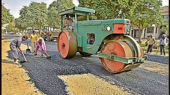 Patch work of damaged roads being carried out by MC workers at Rishi Nagar area in Ludhiana on Wednesday. (HT Photo)